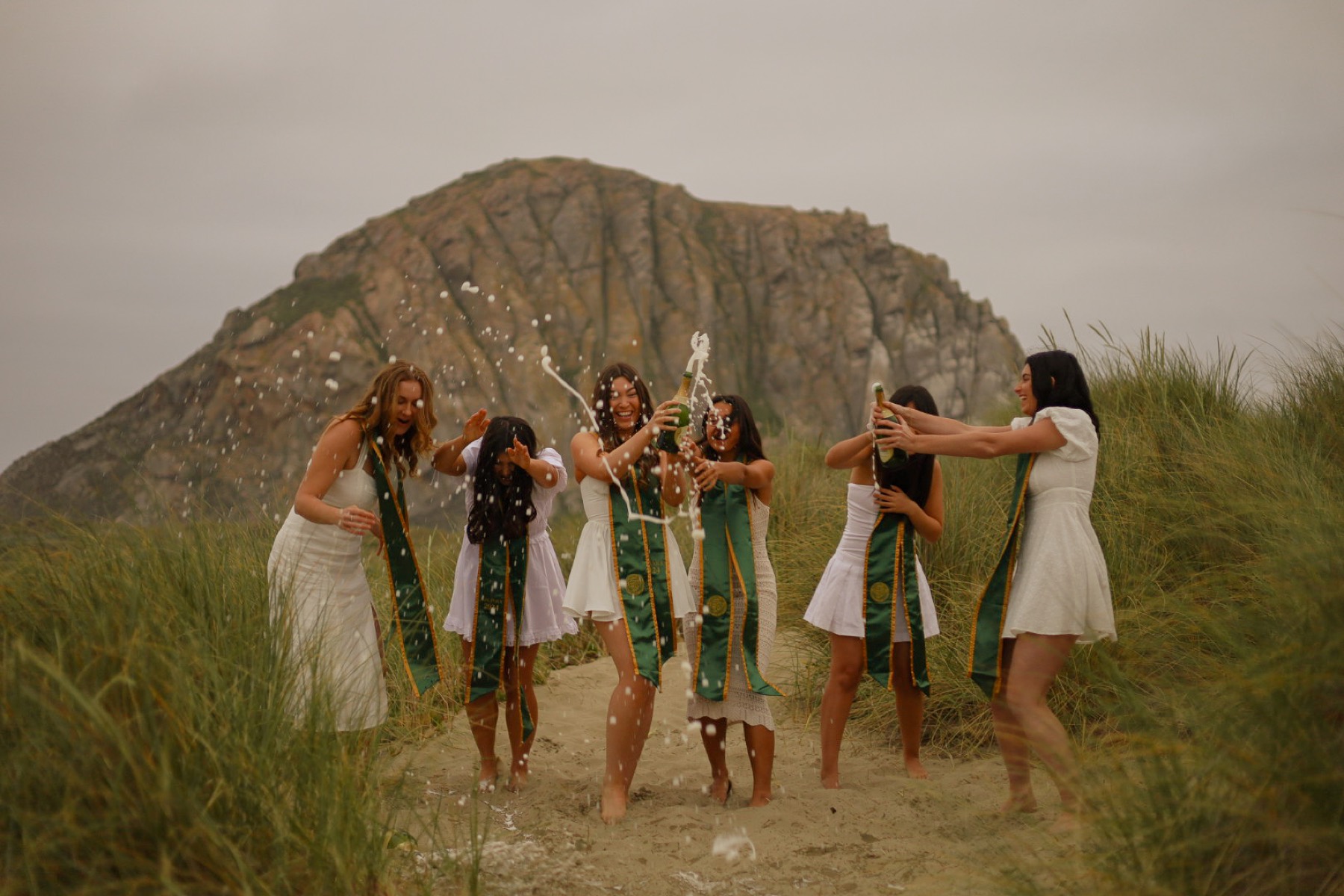Graduates spraying champagne in the dunes at Morro Rock
