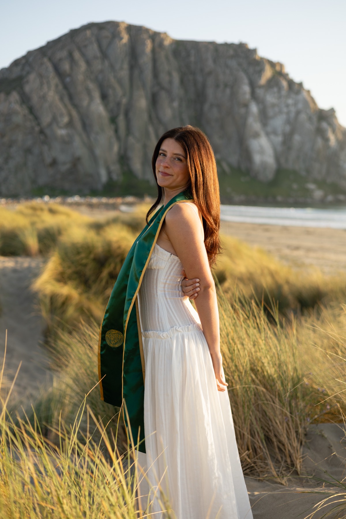 Graduate in a white dress in the dunes below Morro Rock